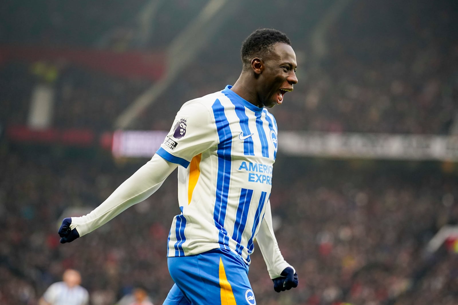 Brighton's Yankuba Minteh celebrates after he scored his side's first goal during the English Premier League soccer match between Manchester United and Brighton and Hove Albion, at the Old Trafford stadium in Manchester, England, Sunday, Jan. 19, 2025. (AP Photo/Dave Thompson)