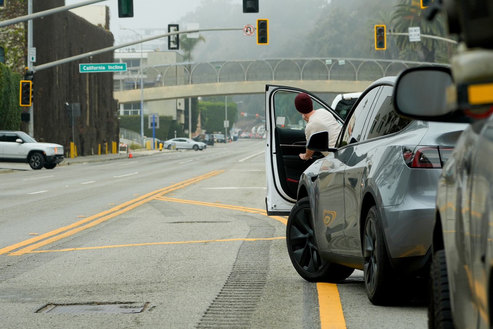 A motorist peeks out of their car as traffic is backed up along Pacific Coast Highway near the Palisades Fire zone Monday, Feb. 3, 2025, in Santa Monica, Calif. (AP Photo/Damian Dovarganes)