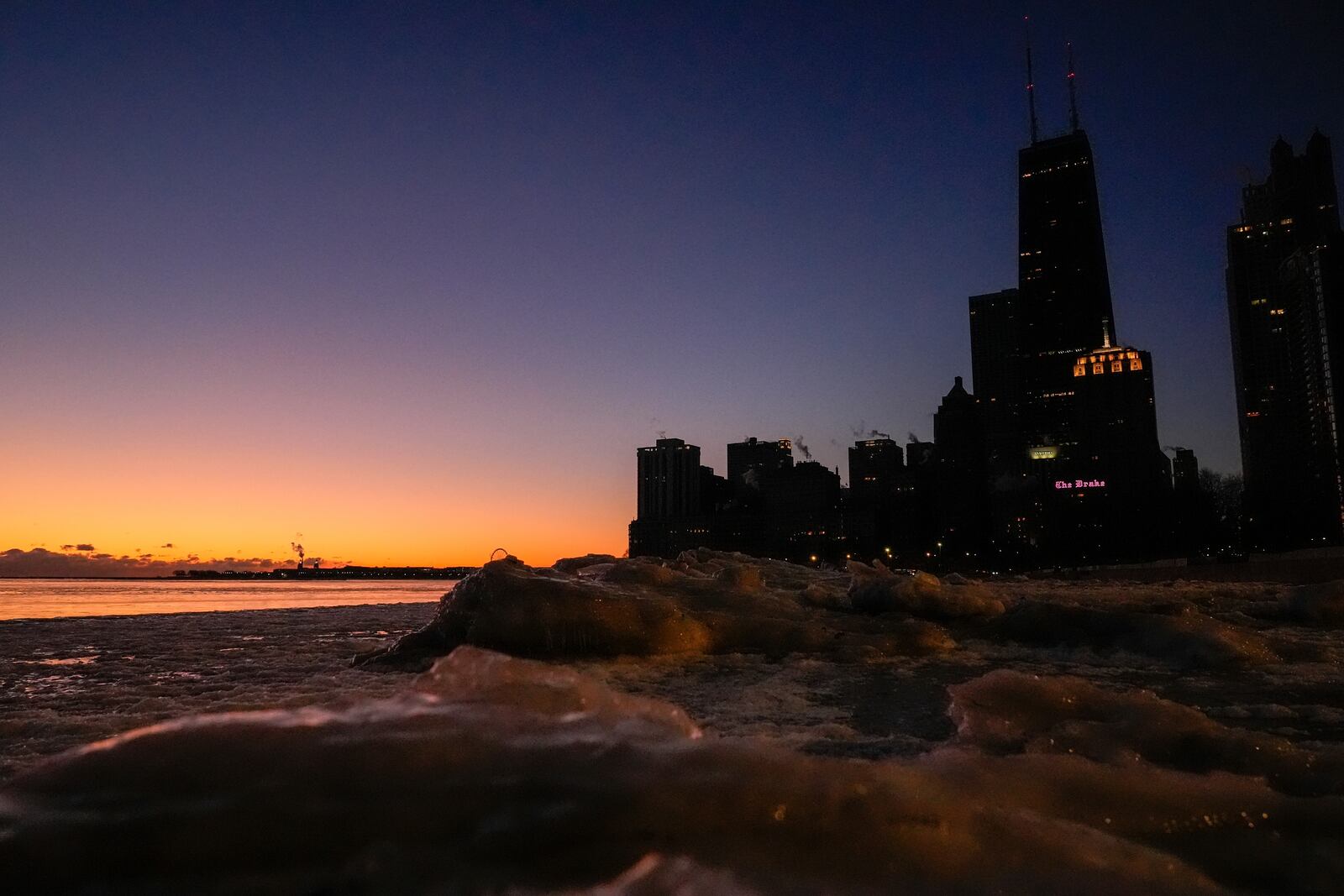 Ice builds up along the shore of Lake Michigan before the sunrise Monday, Jan. 20, 2025, in Chicago as the weather service issued cold weather advisories across the Great Lakes region as high temperatures in many places were expected only to rise into the single digits Monday and Tuesday. (AP Photo/Kiichiro Sato)