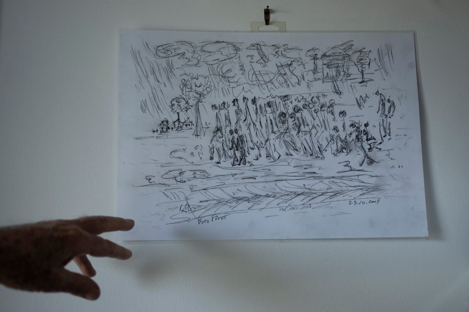 Holocaust survivor Naftali Fürst points to a drawing he drew of he and his brother being forced to march by the Nazis during World War II, at his home in Haifa, Israel, Tuesday, Jan. 14, 2025. (AP Photo/Maya Alleruzzo)