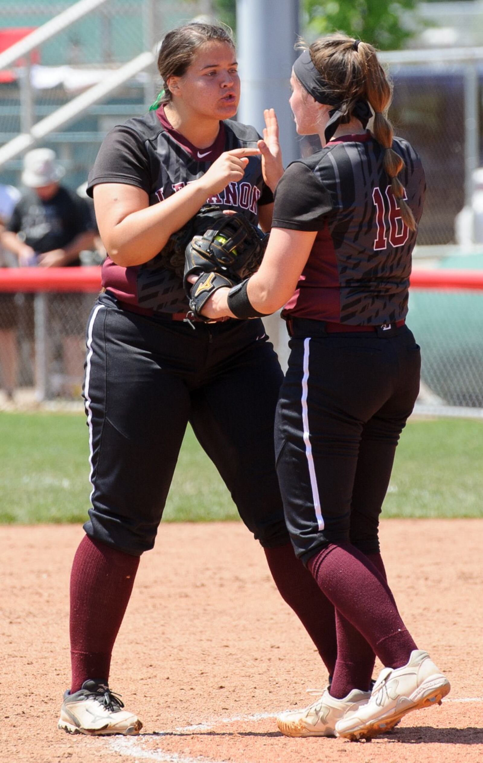 Lebanon’s Alexis Strother (left) talks with pitcher Taylor Lewis during the seventh inning of Saturday’s Division I state final against Elyria at Firestone Stadium in Akron. CONTRIBUTED PHOTO BY BRYANT BILLING