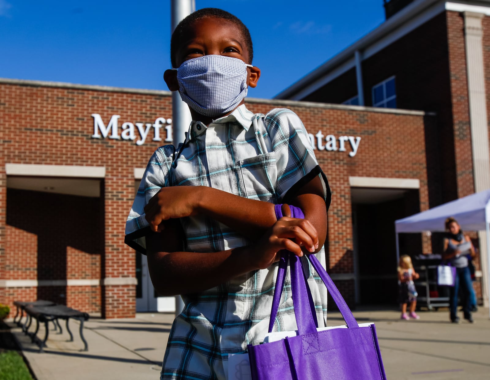 Kavon Chruch Davis, 6, smiles under his face mask after picking up his laptop at Mayfield Elementary School Monday, August 17, 2020 in Middletown. Middletown School district is handing out laptops, mobile hotspots and other supplies this week to students in grades 1 through 12 in preparation for remote learning for the start of the school year. NICK GRAHAM / STAFF 