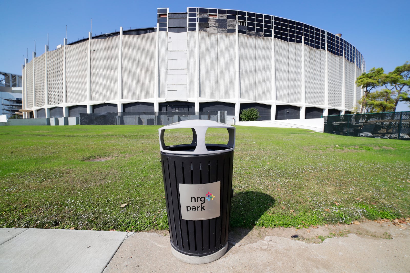 A trashcan sits on the sidewalk outside of the now dormant Astrodome, part of NRG Park, Wednesday, Nov. 13, 2024, in Houston. The Astrodome Conservancy, a group dedicated to preserving the structure, has proposed a multi-use renovation for the once legendary building. (AP Photo/Michael Wyke)