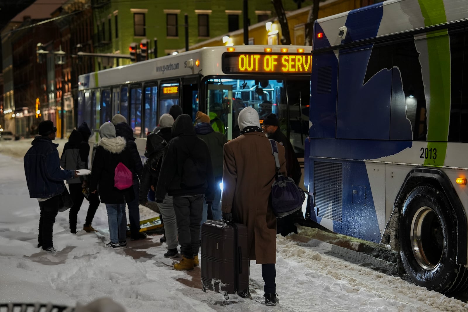 People board a bus to an overnight shelter during a winter storm, Monday, Jan. 6, 2025, in Cincinnati. (AP Photo/Joshua A. Bickel)