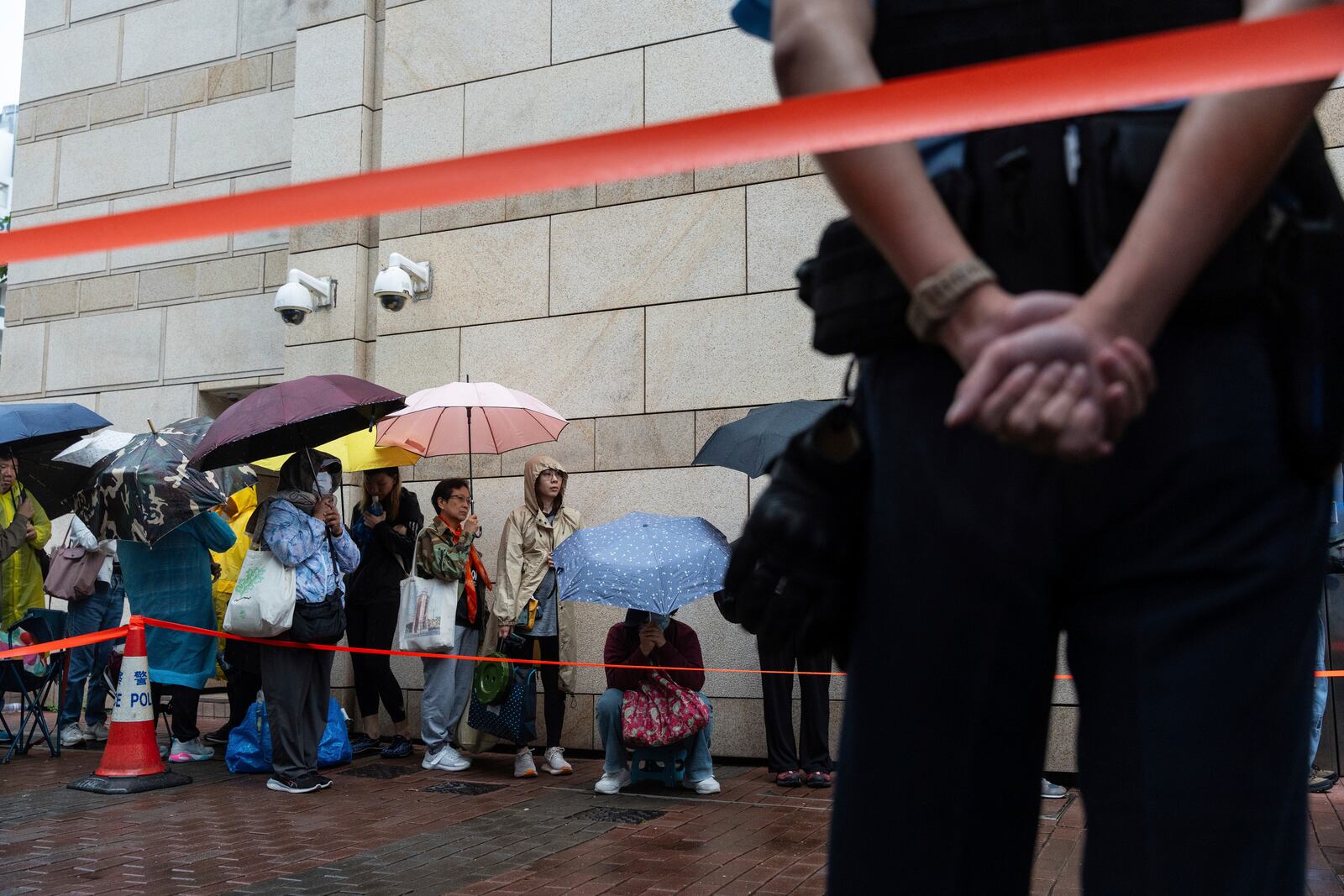 People wait outside the West Kowloon Magistrates' Courts in Hong Kong Tuesday, Nov. 19, 2024, ahead of the sentencing in national security case. (AP Photo/Chan Long Hei)