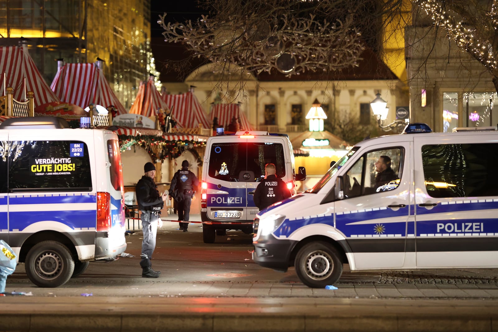 Police officers and police emergency vehicles are seen at the Christmas market in Magdeburg after a driver plowed into a busy Christmas market in Magdeburg, Germany, Saturday, Dec. 21, 2024. (Matthias Bein/dpa via AP)