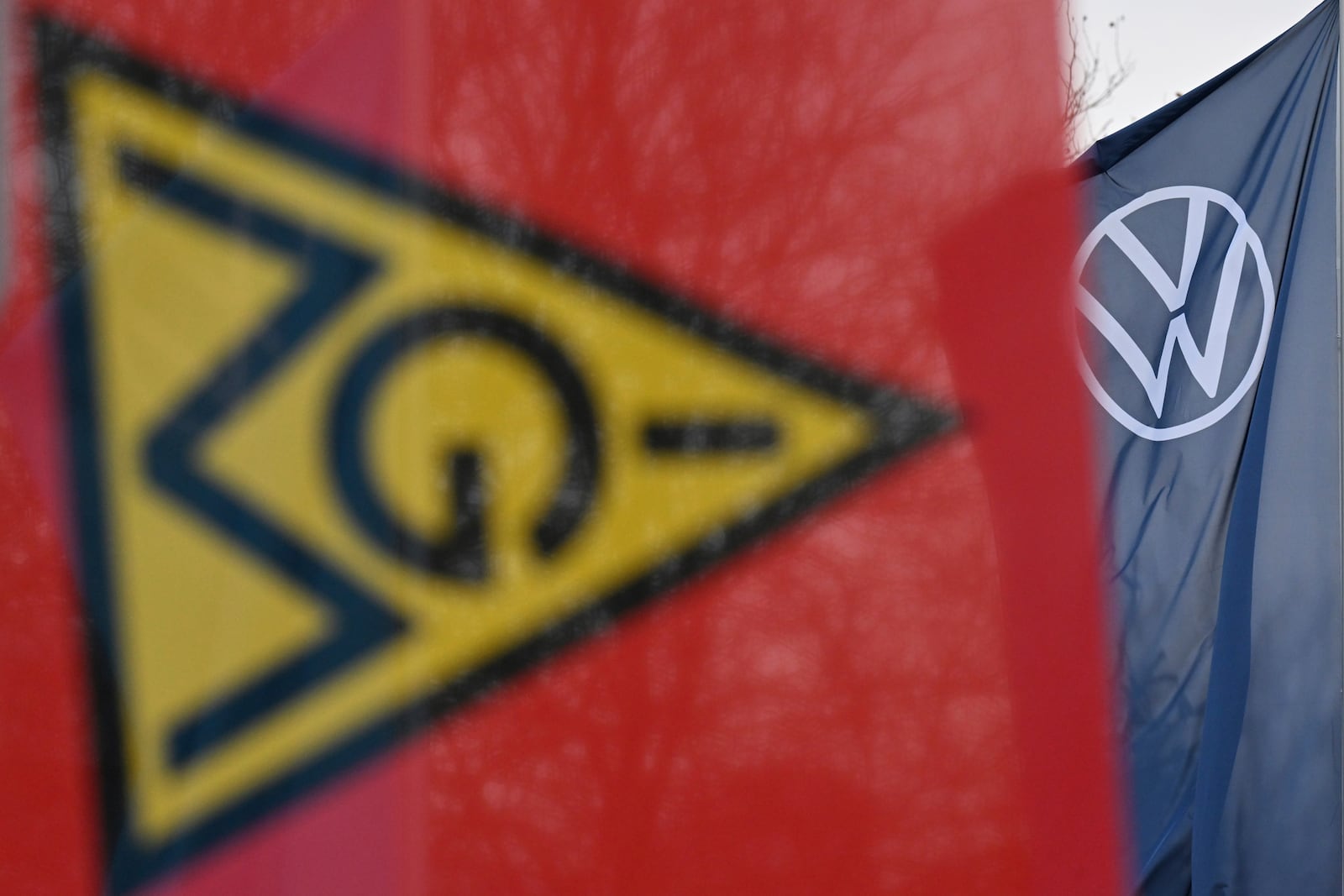 An IG Metall trade union flag flies at the gate of a Volkswagen plant on the first day of a nationwide Volkswagen workers' strike, in Zwickau, Germany, Monday, Dec. 2, 2024. (Hendrik Schmidt/dpa via AP)