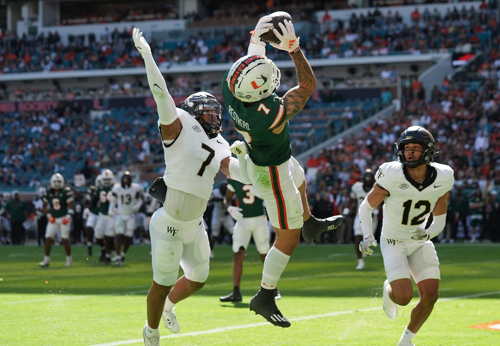 Miami wide receiver Xavier Restrepo (7) makes a catch in the end zone as Wake Forest defensive back Evan Slocum (7) defends during the first half of an NCAA college football game, Saturday, Nov. 23, 2024, in Miami Gardens, Fla. The play was called back due to a penalty on Miami. (AP Photo/Lynne Sladky)