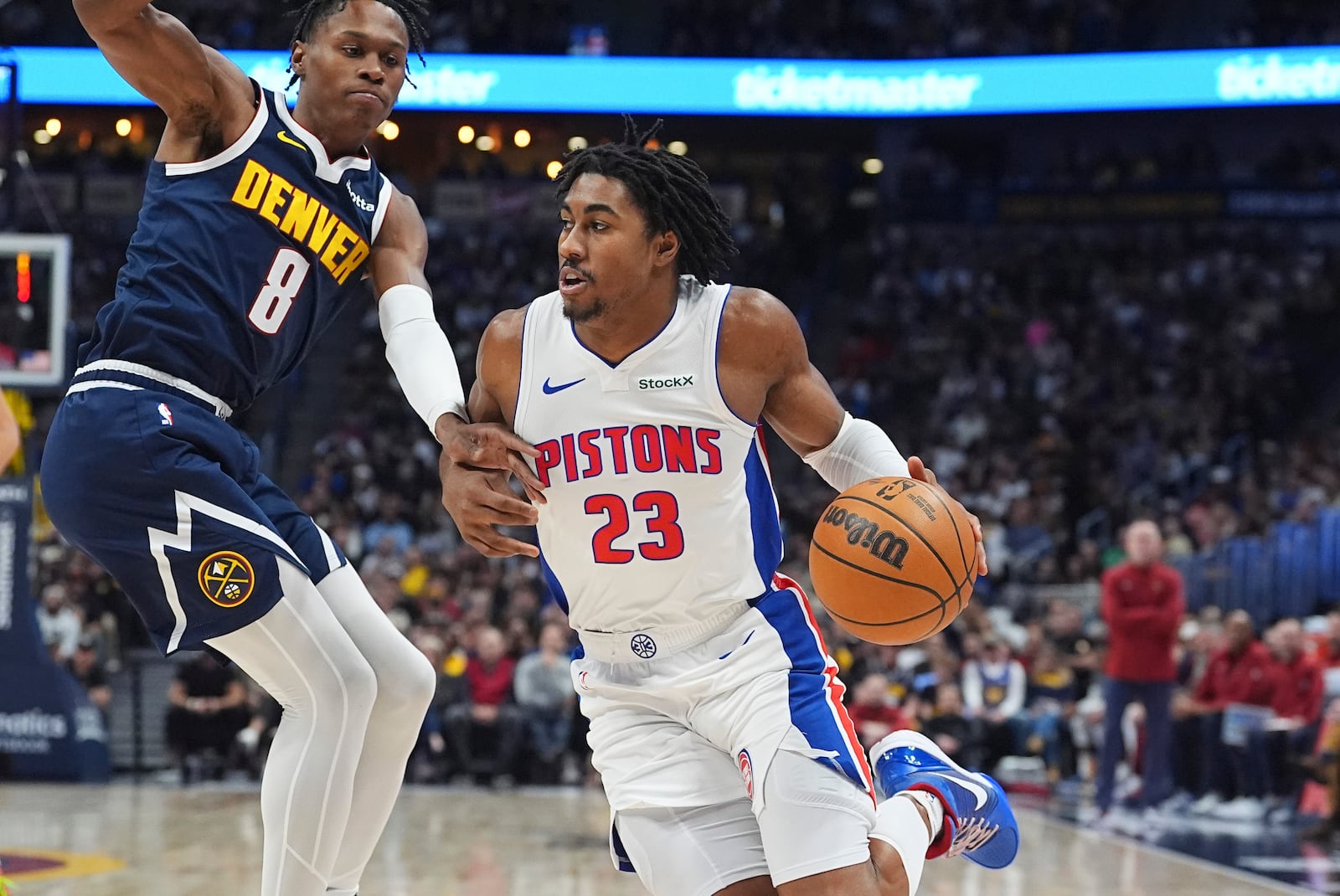 Detroit Pistons guard Jaden Ivey, right, drives to the basket as Denver Nuggets forward Peyton Watson defends in the first half of an NBA basketball game Saturday, Dec. 28, 2024, in Denver. (AP Photo/David Zalubowski)