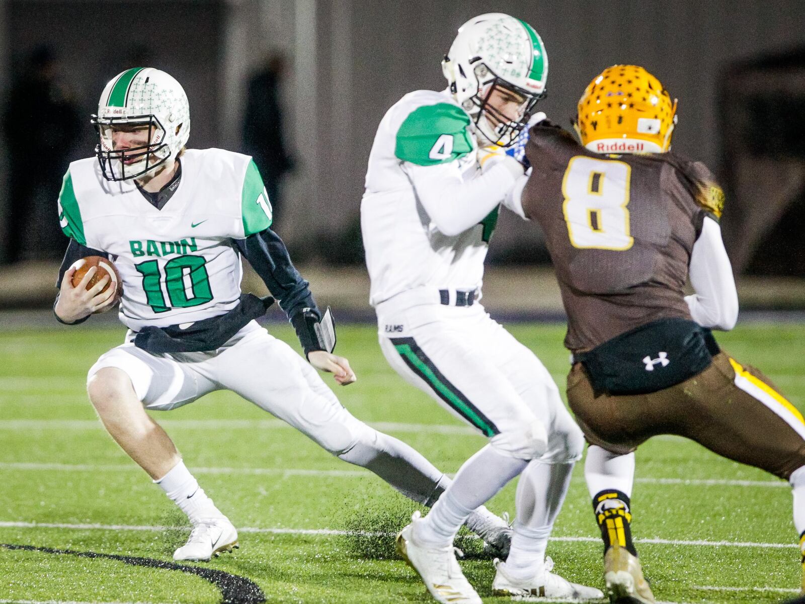 Badin’s Luke Tabler (4) puts a block on Alter’s Matthew Schimpf (8) as BHS quarterback Zach Switzer carries the ball Friday night during a Division III, Region 12 playoff semifinal at Barnitz Stadium in Middletown. NICK GRAHAM/STAFF