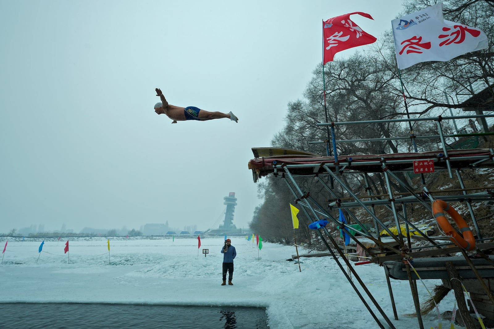 A man jumps into a pool carved from ice on the frozen Songhua river in Harbin in northeastern China's Heilongjiang province, Tuesday, Jan. 7, 2025. (AP Photo/Andy Wong)