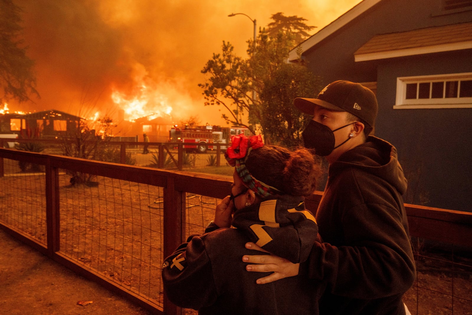 People watch as the Eaton Fire destroys a neigborhood Wednesday, Jan. 8, 2025 in Altadena, Calif. (AP Photo/Ethan Swope)