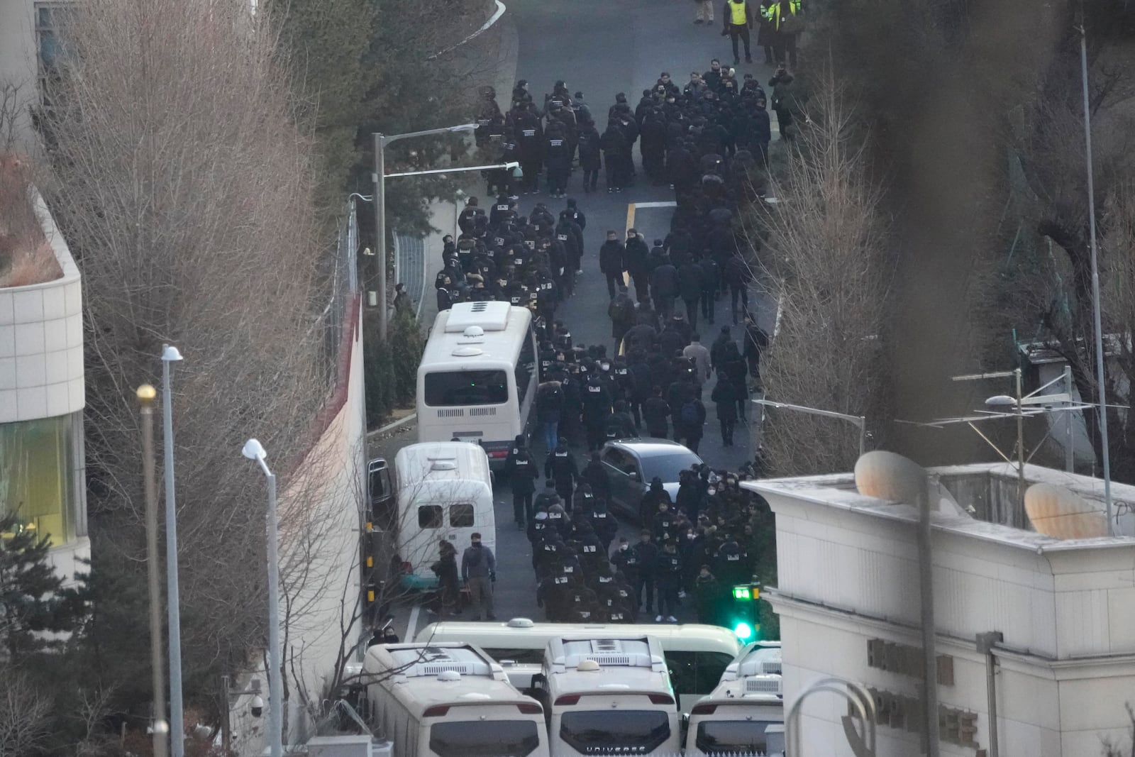 Investigators from the state anti-corruption agency and police officers make their way to the residence of impeached President Yoon Suk Yeol to execute a warrant to detain Yoon in Seoul, South Korea, Wednesday, Jan. 15, 2025. (AP Photo/Ahn Young-joon)