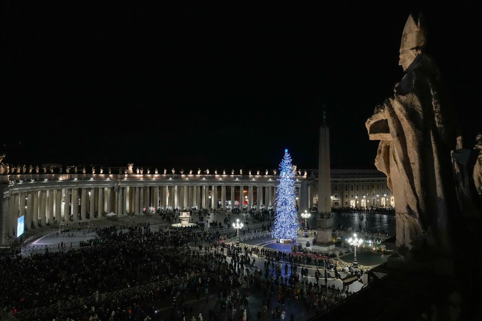 Faithful and pilgrims wait in St. Peter's Square for the opening of the holy door of St. Peter's Basilica at The Vatican, Tuesday, Dec. 24, 2024, marking the start of the Catholic jubiliar year 2025. (AP Photo/Gregorio Borgia)