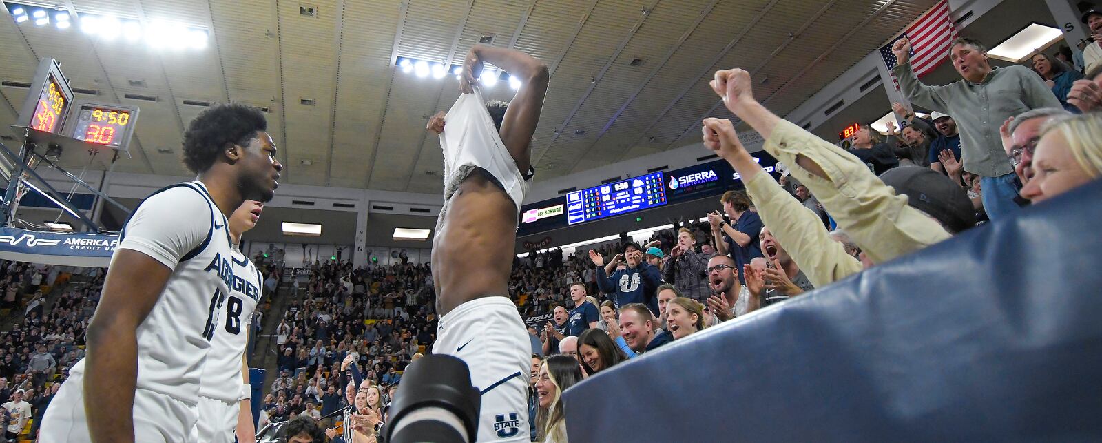 Utah State guard Dexter Akanno, center, celebrates with guard Deyton Albury (13) and guard Drake Allen (8) after getting fouled while dunking against Fresno State in the second half of an NCAA college basketball game Saturday, Jan. 4, 2025, in Logan, Utah. (Eli Lucero/The Herald Journal via AP)