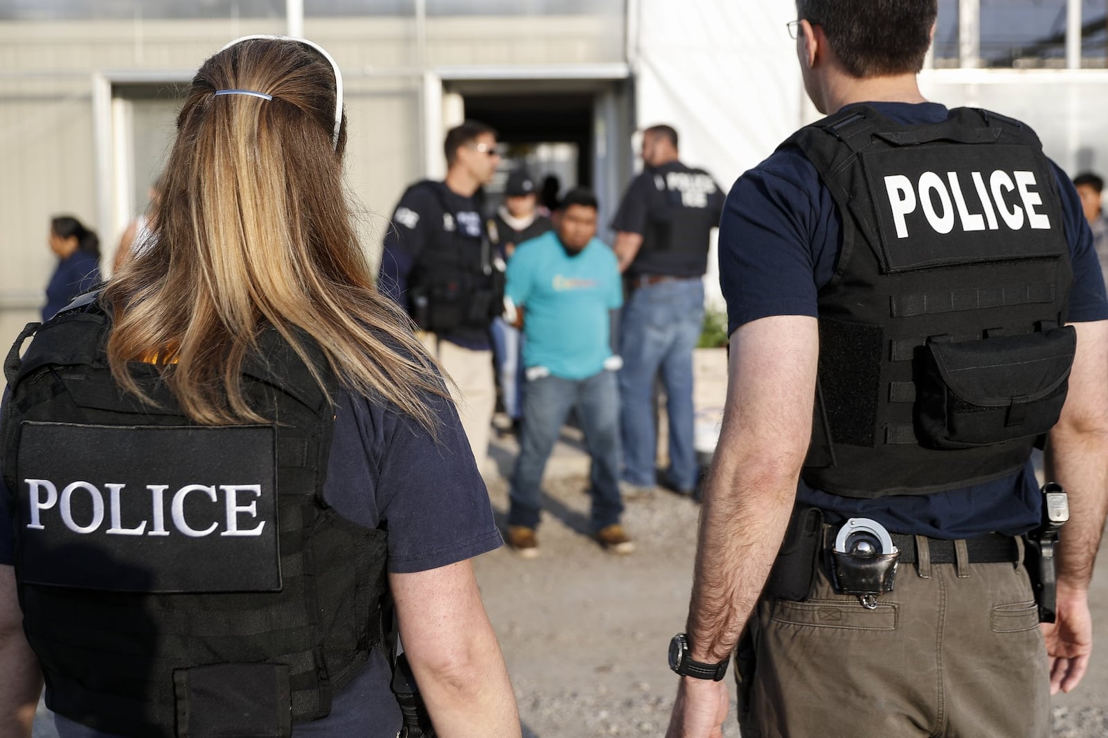 Government agents take a suspect into custody during an immigration sting at Corso’s Flower and Garden Center, Tuesday, June 5, 2018, in Castalia, Ohio. The operation is one of the largest against employers in recent years on allegations of violating immigration laws. (AP Photo/John Minchillo)