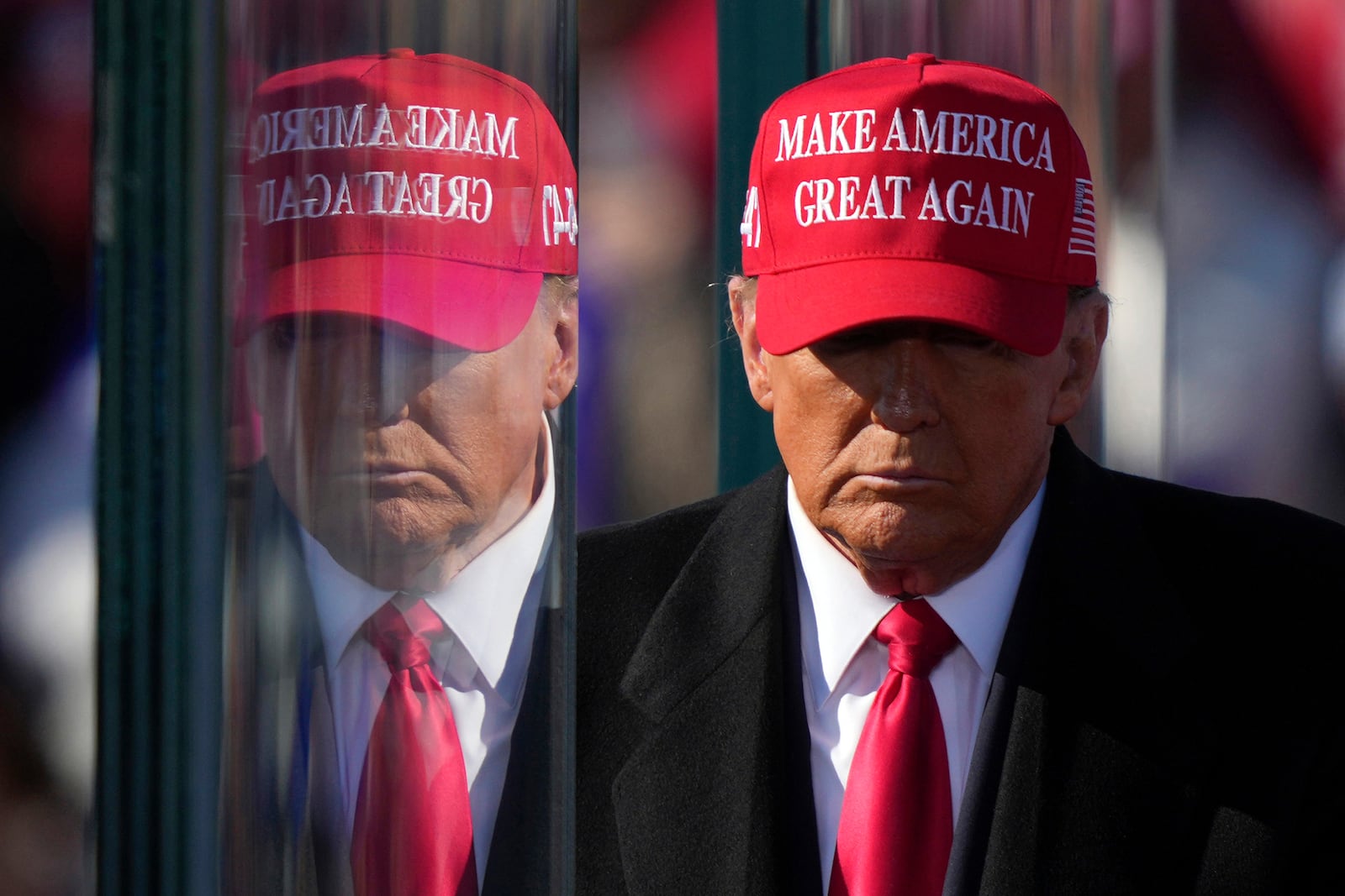 Republican presidential nominee former President Donald Trump is reflected in the bullet proof glass as he finishes speaking at a campaign rally in Lititz, Pa., Sunday, Nov. 3, 2024. (AP Photo/Matt Rourke)