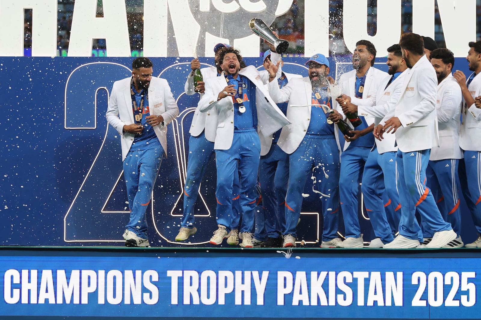 Indian players celebrate with the winners trophy on the podium after defeating New Zealand in the final cricket match of the ICC Champions Trophy at Dubai International Cricket Stadium in Dubai, United Arab Emirates, Sunday, March 9, 2025. (AP Photo/Christopher Pike)