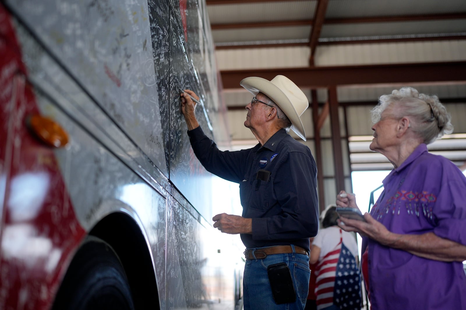 Darren Mosley, left, signs Sen. Ted Cruz's campaign bus during a campaign rally Tuesday, Oct. 29, 2024, in Jourdanton, Texas. (AP Photo/Eric Gay)