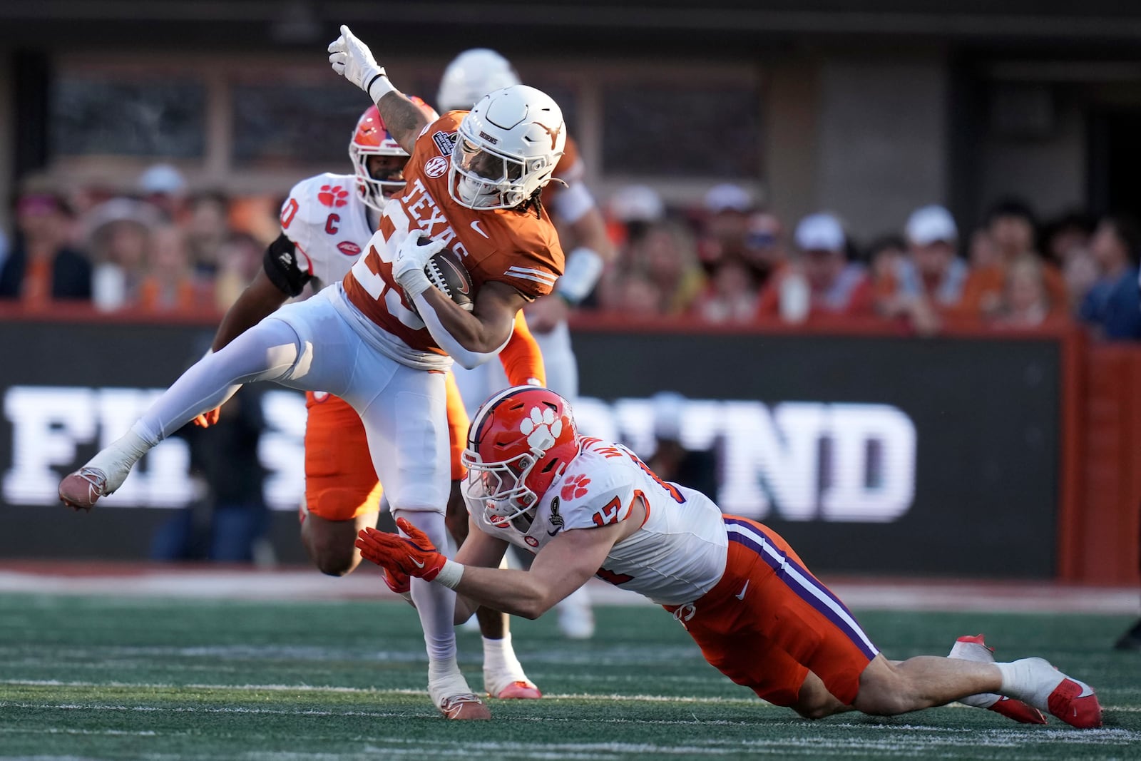 Texas running back Jaydon Blue (23) tries to break a tackle by Clemson linebacker Wade Woodaz (17) during the first half in the first round of the College Football Playoff, Saturday, Dec. 21, 2024, in Austin, Texas. (AP Photo/Eric Gay)