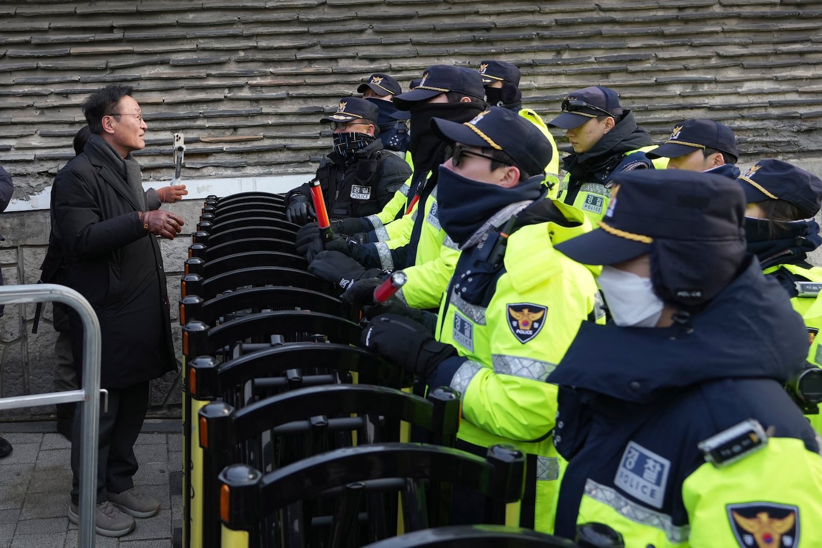 A member of civic groups is blocked by police offices after a news conference demanding the arrest of President Yoon Suk Yeol near the presidential residence in Seoul, South Korea, Tuesday, Dec. 17, 2024. (AP Photo/Lee Jin-man)