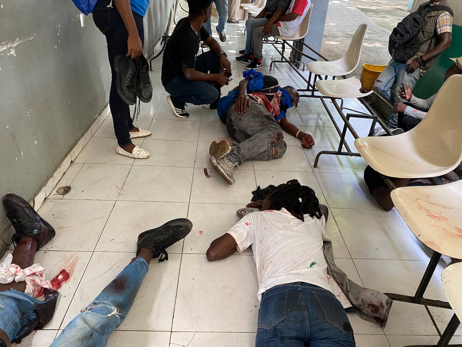 Journalists lie wounded after being shot by armed gangs at the general hospital in Port-au-Prince, Haiti, Tuesday, Dec. 24, 2024. (AP Photo/Dieugo Andre)