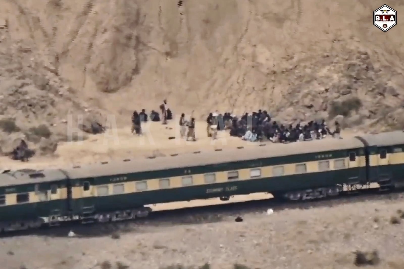 In this frame grab from a video released by the Baluchistan Liberation Army shows people outside the a train after being attacked by the BLA on its transit from Quetta to the northern city of Peshawar, in Bolan district, Pakistan's southwestern Balochistan province, March 12, 2025..(BLA via AP)