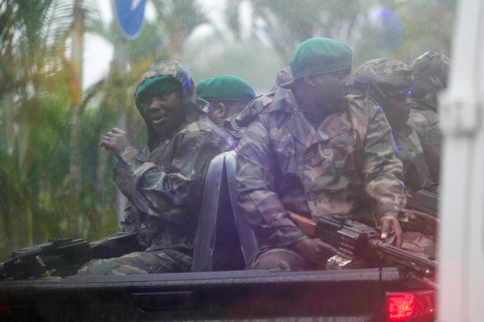 Seen through a vehicle window, Angolan soldiers escort President Joe Biden motorcade in the rain in the capital Luanda, Angola on Tuesday, Dec. 3, 2024. (AP Photo/Ben Curtis)