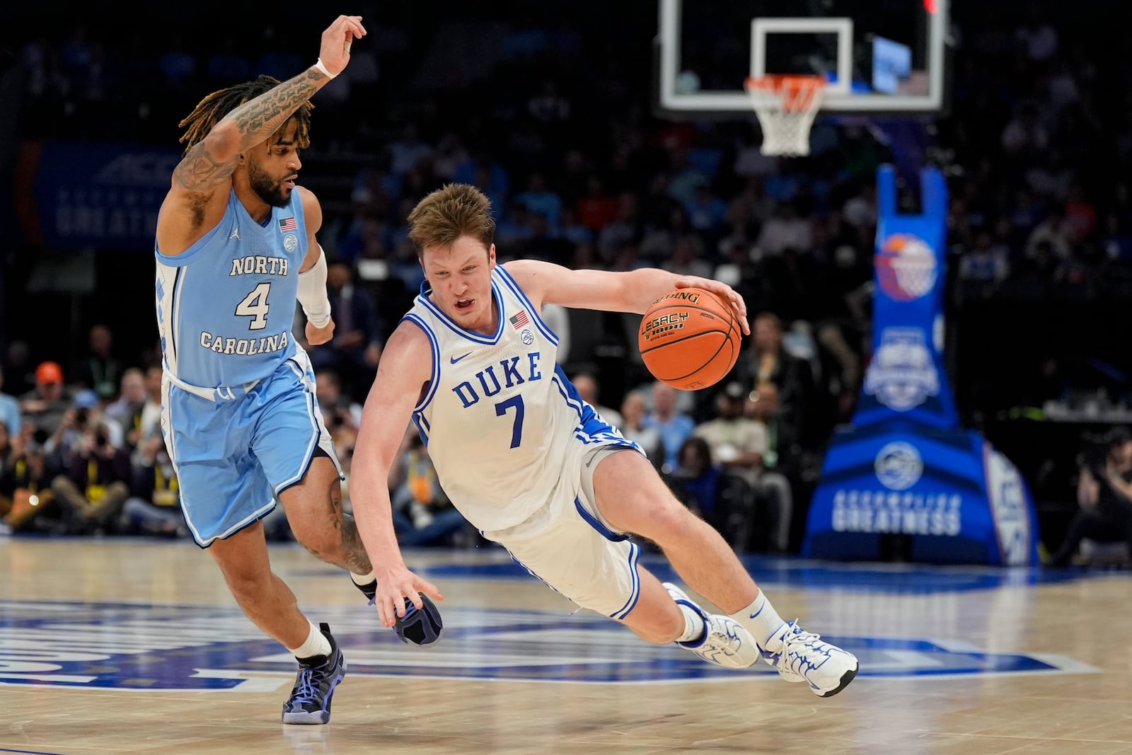 Duke guard Kon Knueppel slips going around North Carolina guard RJ Davis during the second half of an NCAA college basketball game in the semifinals of the Atlantic Coast Conference tournament, Friday, March 14, 2025, in Charlotte, N.C. (AP Photo/Chris Carlson)