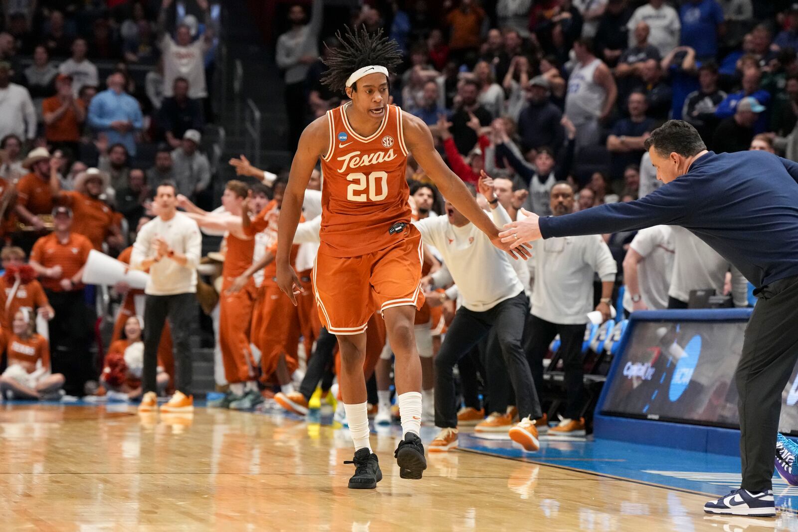 Texas guard Tre Johnson (20) celebrates with Xavier head coach Sean Miller after scoring during the second half of a First Four college basketball game in the NCAA Tournament, Wednesday, March 19, 2025, in Dayton, Ohio. (AP Photo/Jeff Dean)