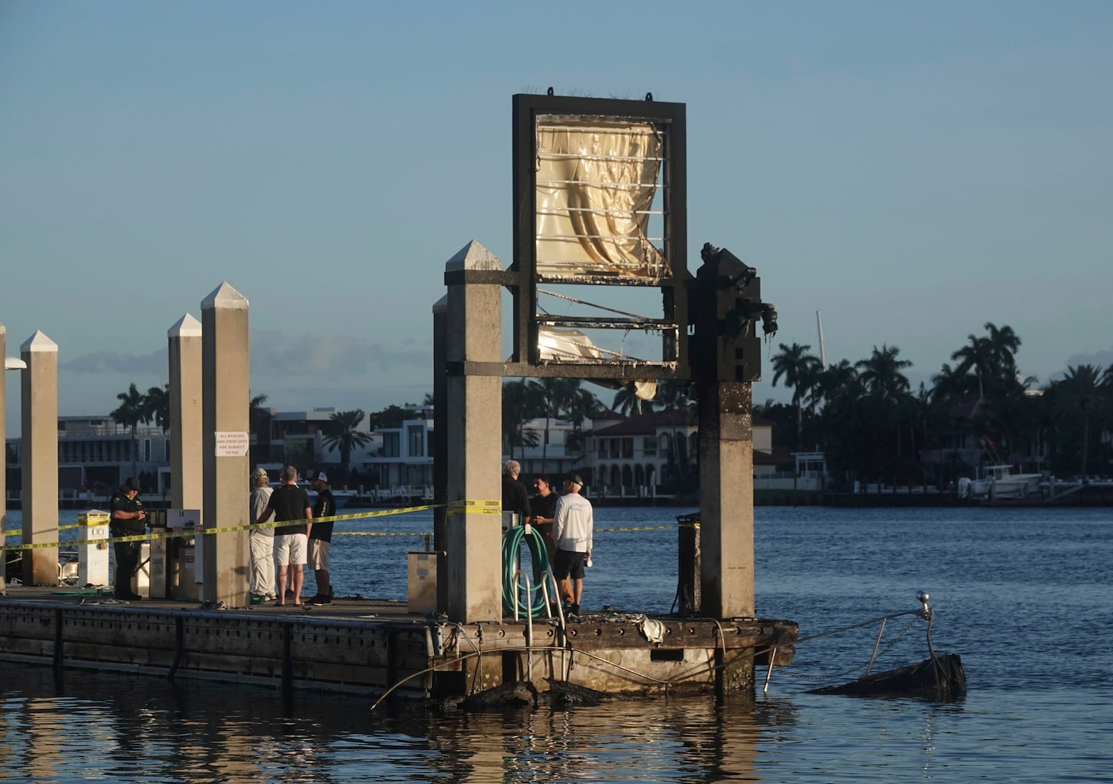 The charred remains of two boats are seen Tuesday, Dec. 24, 2024, at Lauderdale Marina near the 15th Street Fisheries restaurant in Fort Lauderdale, Fla. (Joe Cavaretta/South Florida Sun-Sentinel via AP)