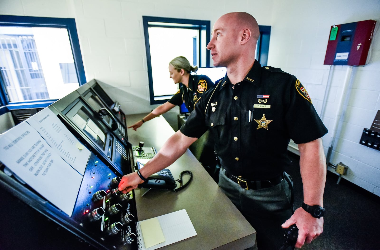 Butler County Sheriff’s Office corrections officers Waylon Thomas and Hannah McCarthy stand in the control room of the old Butler County Court Street Jail that was re-opened recently, in part because a new law takes effect July 1 that prohibits judges from sending felony five offenders to prison. 