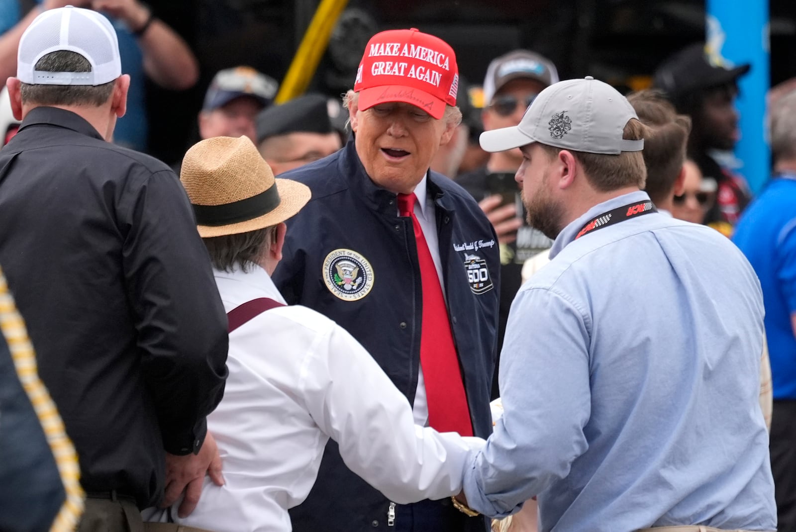 Jack Roush, center left, greets President Donald Trump, center right, at the NASCAR Daytona 500 auto race at Daytona International Speedway, Sunday, Feb. 16, 2025, in Daytona Beach, Fla. (AP Photo/John Raoux)