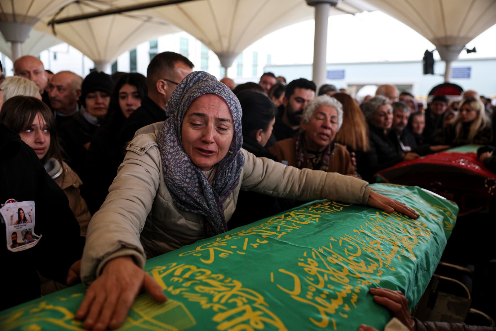 Relatives and friends mourn during the funeral of Yilmaz Saritas and his children Nehir and Doruk, who were among the 76 victims who died in a fire at the Kartalkaya ski resort in Bolu province, at Karsıyaka cemetery in Ankara, Wednesday, Jan. 22, 2025. (Ugur Yildirim/Dia Photo via AP)