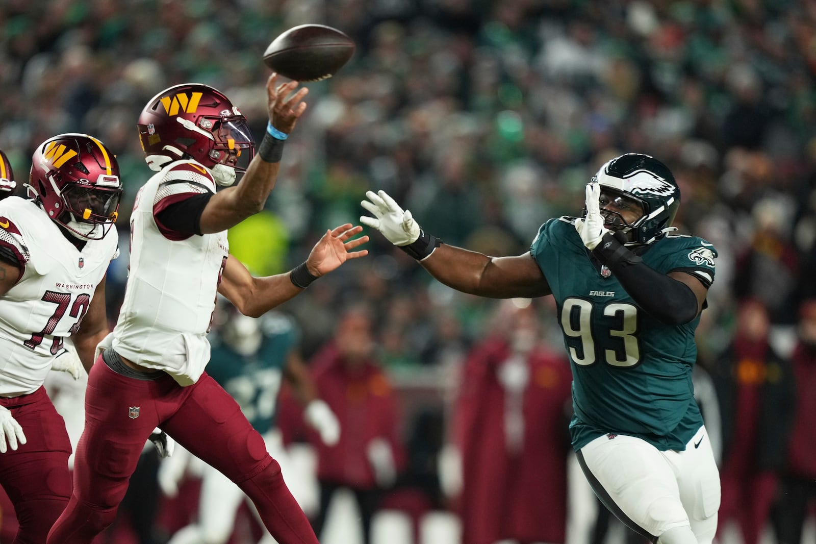 Washington Commanders quarterback Jayden Daniels, left, is pressured by Philadelphia Eagles defensive tackle Milton Williams (93) during the second half of the NFC Championship NFL football game, Sunday, Jan. 26, 2025, in Philadelphia. (AP Photo/Matt Slocum)