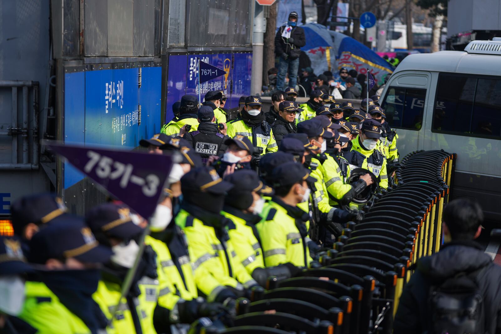 Police officers stand guard as motorcade for impeached South Korean President Yoon Suk Yeol heads to the Constitutional Court in Seoul, South Korea, Tuesday, Jan. 21, 2025. (AP Photo/Lee Jin-man)