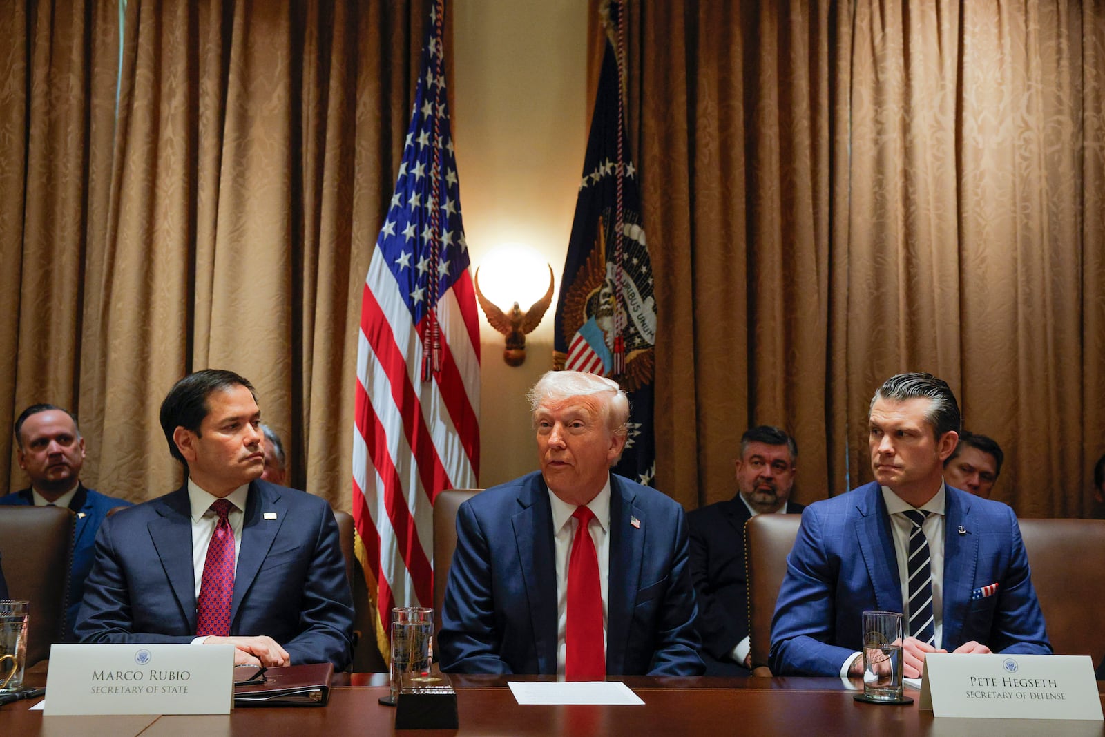 President Donald Trump speaks during a Cabinet meeting at the White House in Washington, Tuesday, Feb. 26, 2025, as Secretary of State Marco Rubio and Defense Secretary Pete Hegseth listen. (Pool via AP)