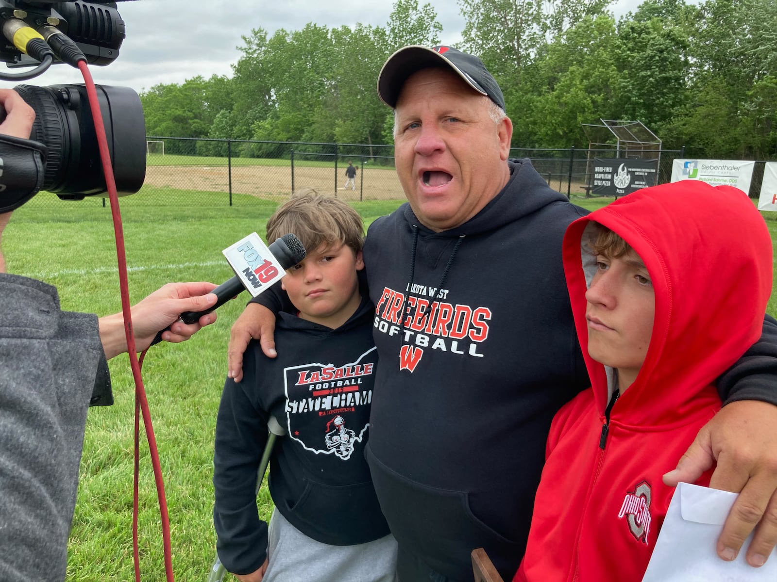 Lakota West coach Keith Castner gives an interview with his sons after a victory against Beavercreek in a Division I regional championship on Saturday, May 29, 2021, at Centerville High School. David Jablonski/Staff