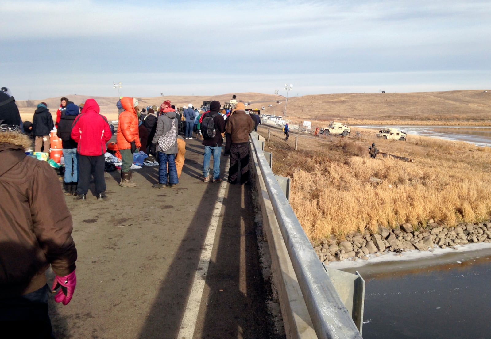 FILE - Protesters against the Dakota Access oil pipeline congregate, Nov. 21, 2016, on a long-closed bridge on a state highway near Cannon Ball., N.D. near their camp in southern North Dakota. (AP Photo/James MacPherson, File)