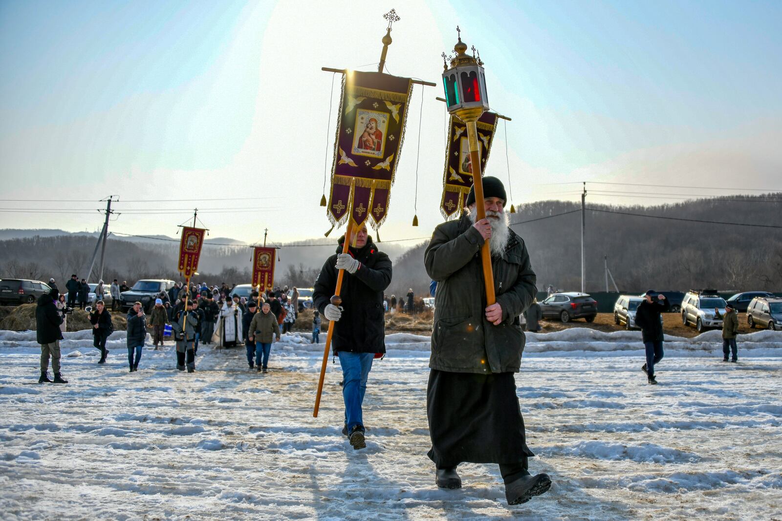 Participants of a religion procession walk to bless the icy water before celebrating the Orthodox Epiphany near the St. Serafimovsky Monastery on Russian Island in Russian far east port Vladivostok, Russia, Sunday, Jan. 19, 2025. (AP Photo)