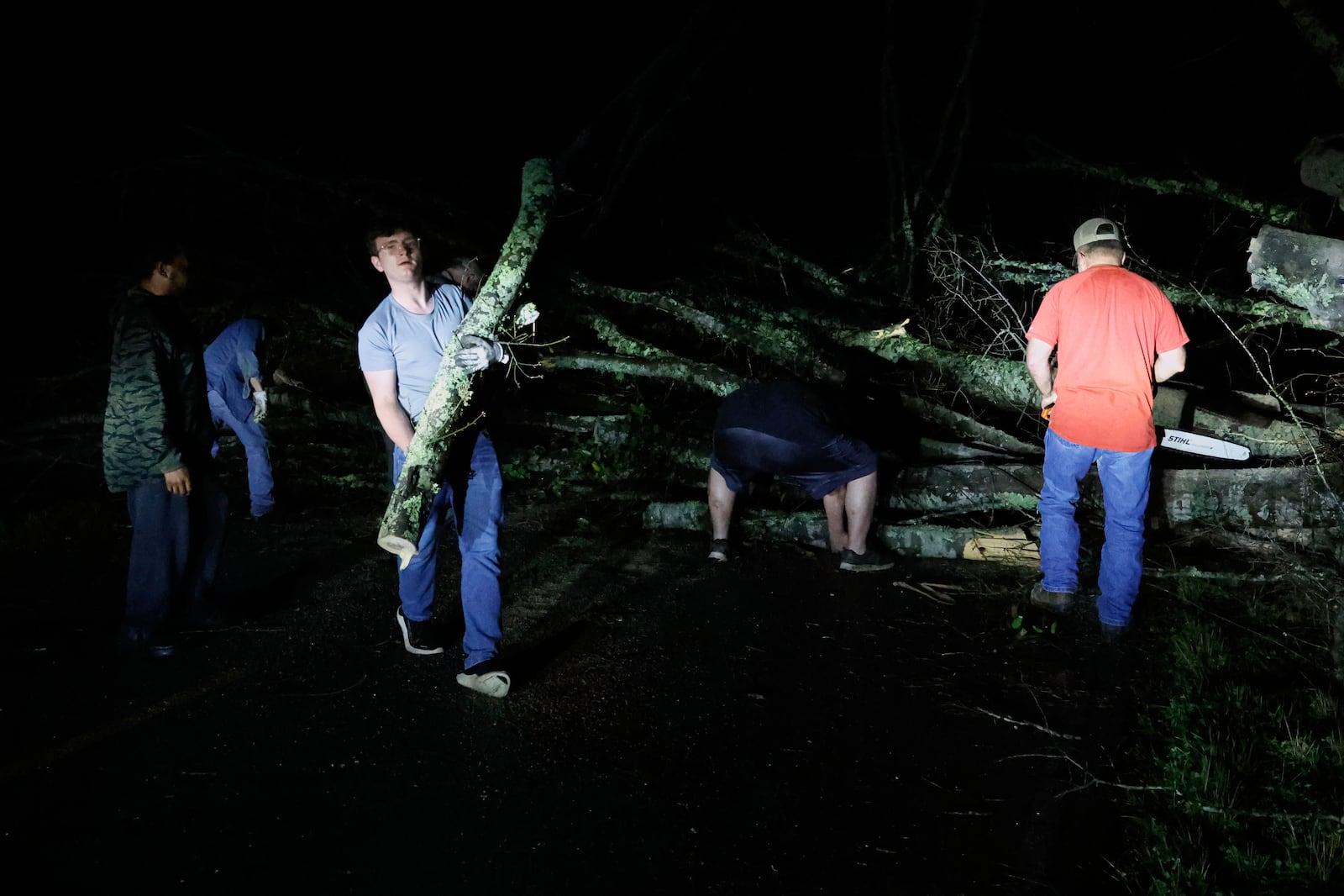 Locals help clear the roads from debris after a tornado passed through leaving a path of destruction, Saturday, March 15, 2025, in Plantersville, Ala. (AP Photo/Butch Dill)