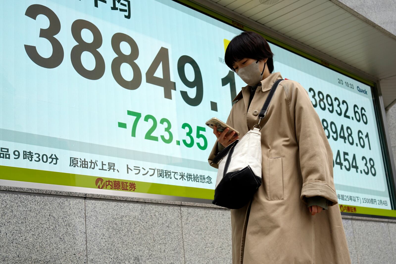 A person walks in front of an electronic stock board showing Japan's Nikkei index at a securities firm Monday, Feb. 3, 2025, in Tokyo. (AP Photo/Eugene Hoshiko)