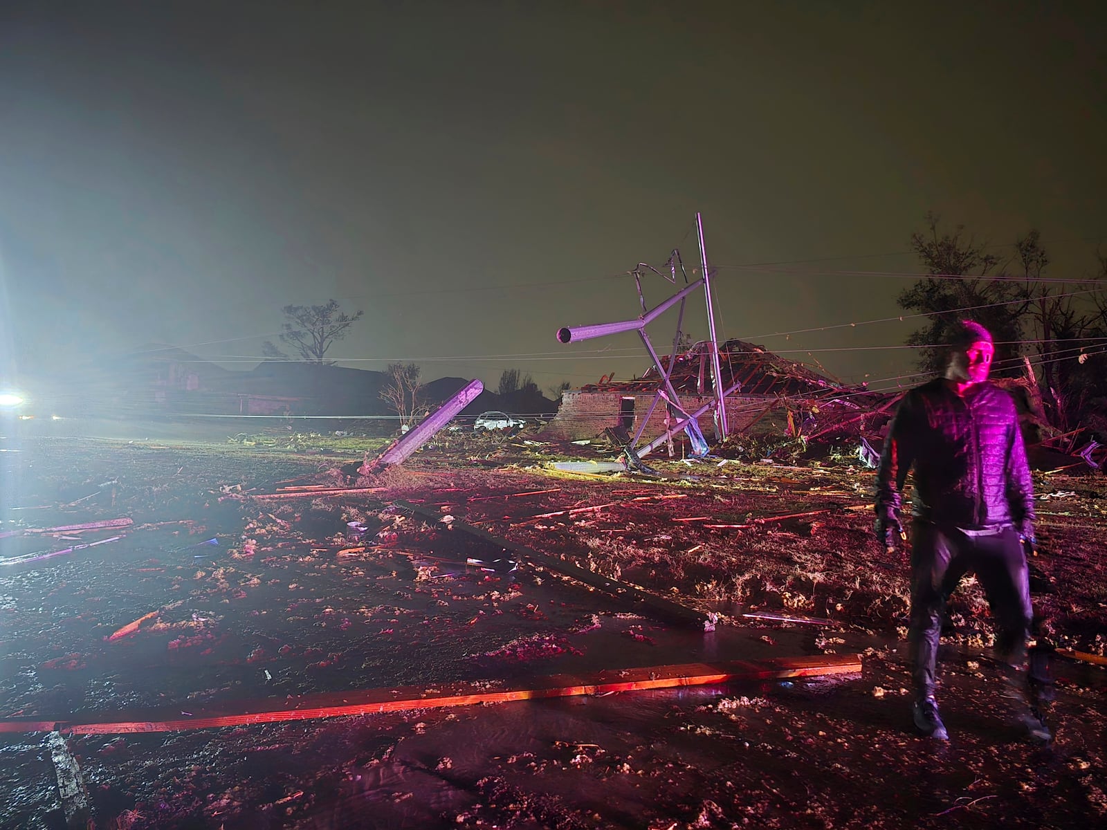 This image provided by Sean Taylor shows an unidentified person talking to firefighters after a tornado hit the area in Midwest City, Okla,, Sunday, Nov. 3, 2024. (Sean Taylor via AP)