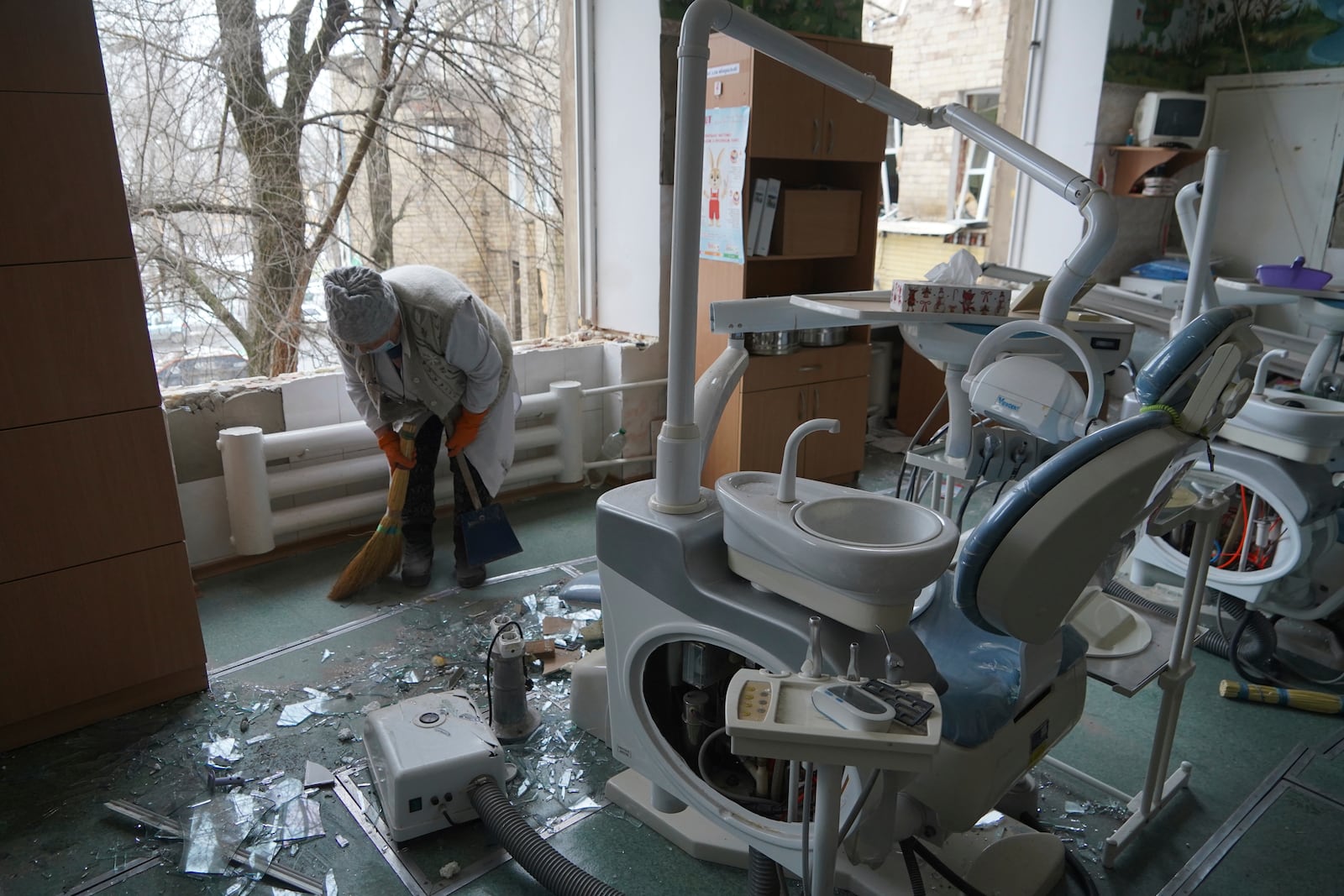 A medical worker sweeps up the glass shards in a hospital damaged by a Russian strike, in Kharkiv, Ukraine, Saturday, March 1, 2025. (AP Photo/Andrii Marienko)