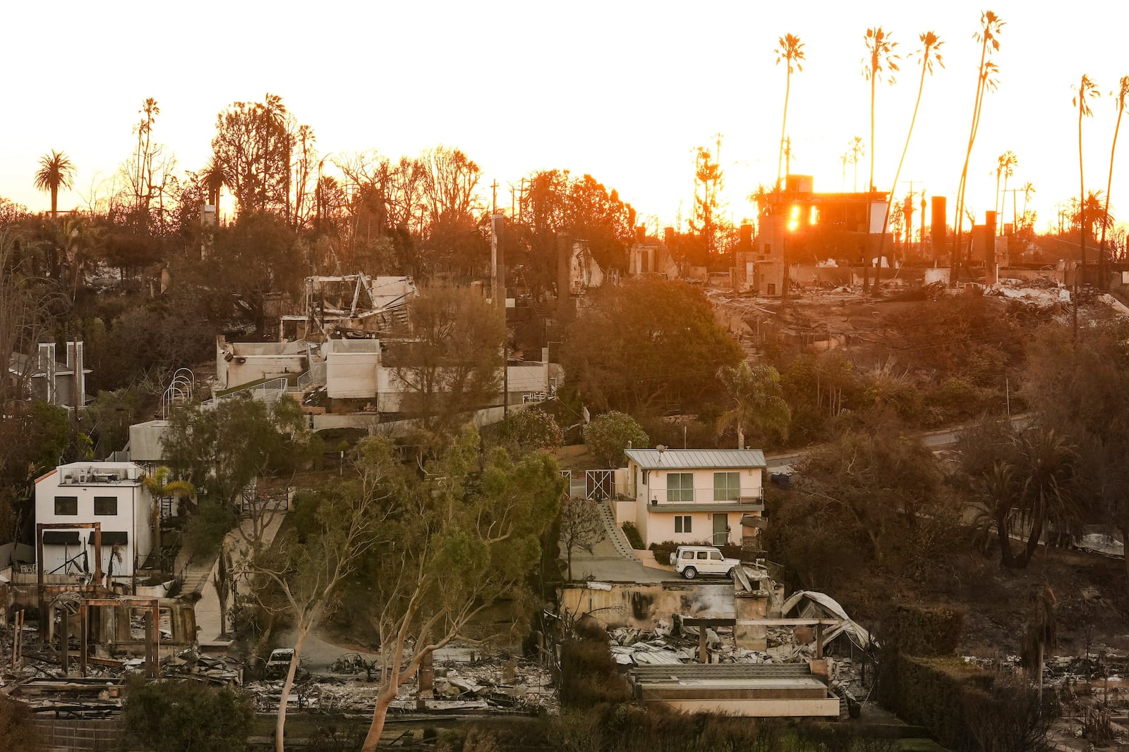 The Sun rises over homes destroyed by the Palisades Fire in the Pacific Palisades neighborhood of Los Angeles, Thursday, Jan. 16, 2025. (AP Photo/Damian Dovarganes)