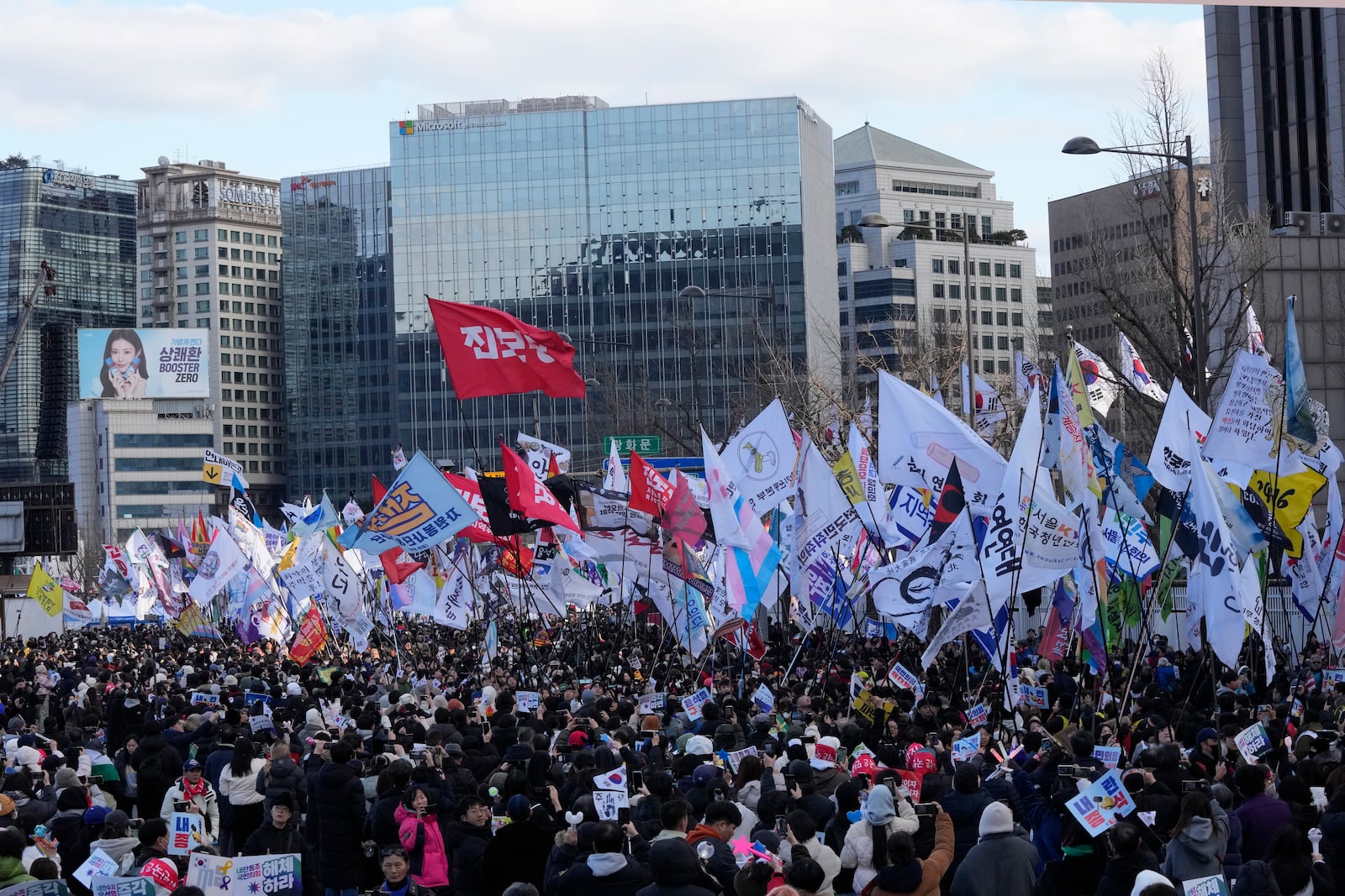 Protesters carry flags during a rally demanding immediate indictment of impeached South Korean President Yoon Suk Yeol in Seoul, South Korea, Saturday, Jan. 25, 2025. (AP Photo/Ahn Young-joon)