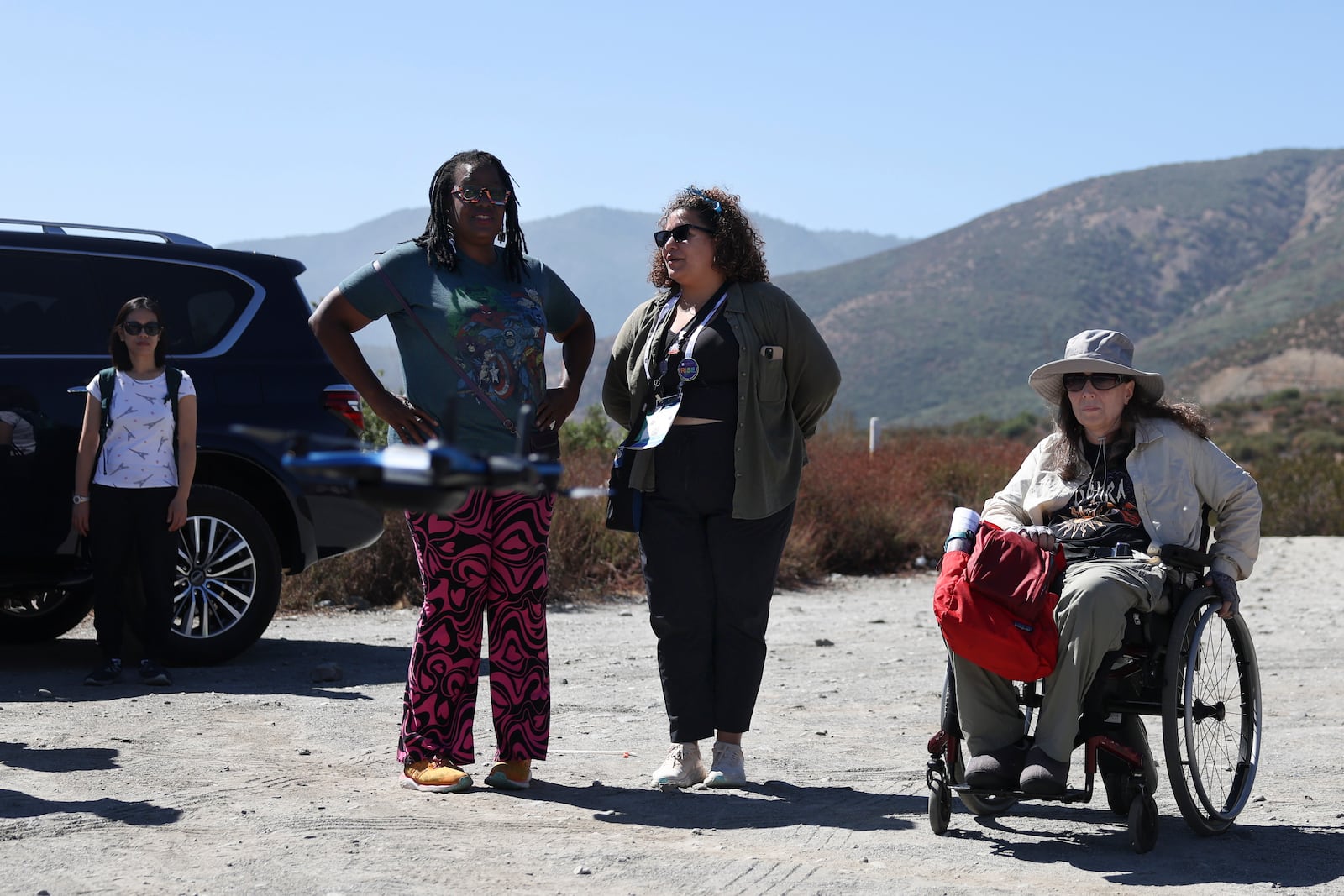 Shirley Jackson, an adjunct professor in general geology at York College, left, stands with Wilnelly Ventura-Valentin, and Jennifer Piatek, a planetary geologist at Central Connecticut State University as they watch a drone used to allow people to survey the San Andreas Fault during an accessible field trip organized by the International Association of Geoscience Diversity Thursday, Sept. 26, 2024, in San Bernadino, Calif. (AP Photo/Ryan Sun)