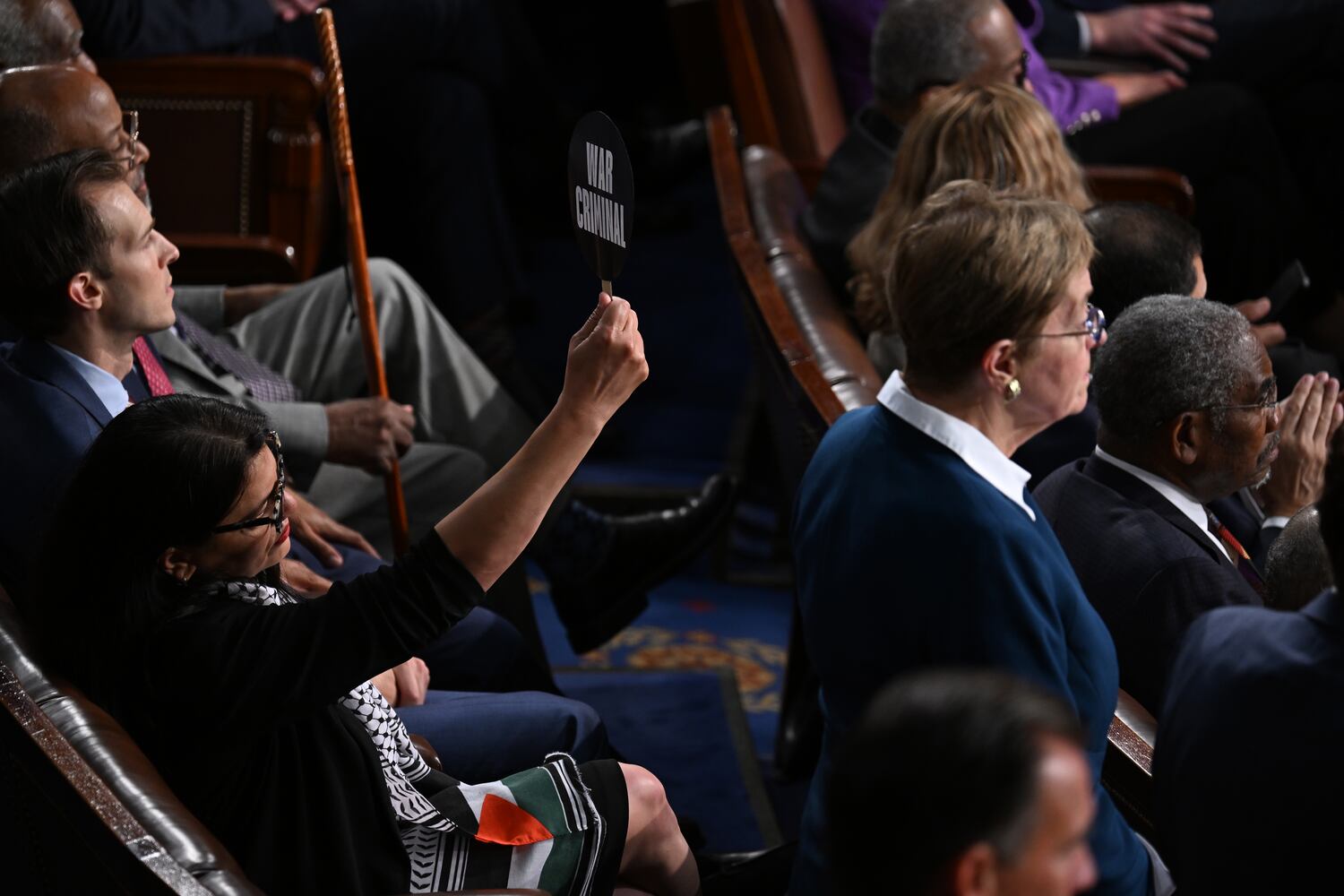 Rep. Rashida Tlaib (D-Mich.) holds up a sign that says ÒWar CriminalÓ as Prime Minister Benjamin Netanyahu of Israel speaks to a joint session of Congress at the Capitol in Washington on Wednesday, July 24, 2024. (Kenny Holston/The New York Times)