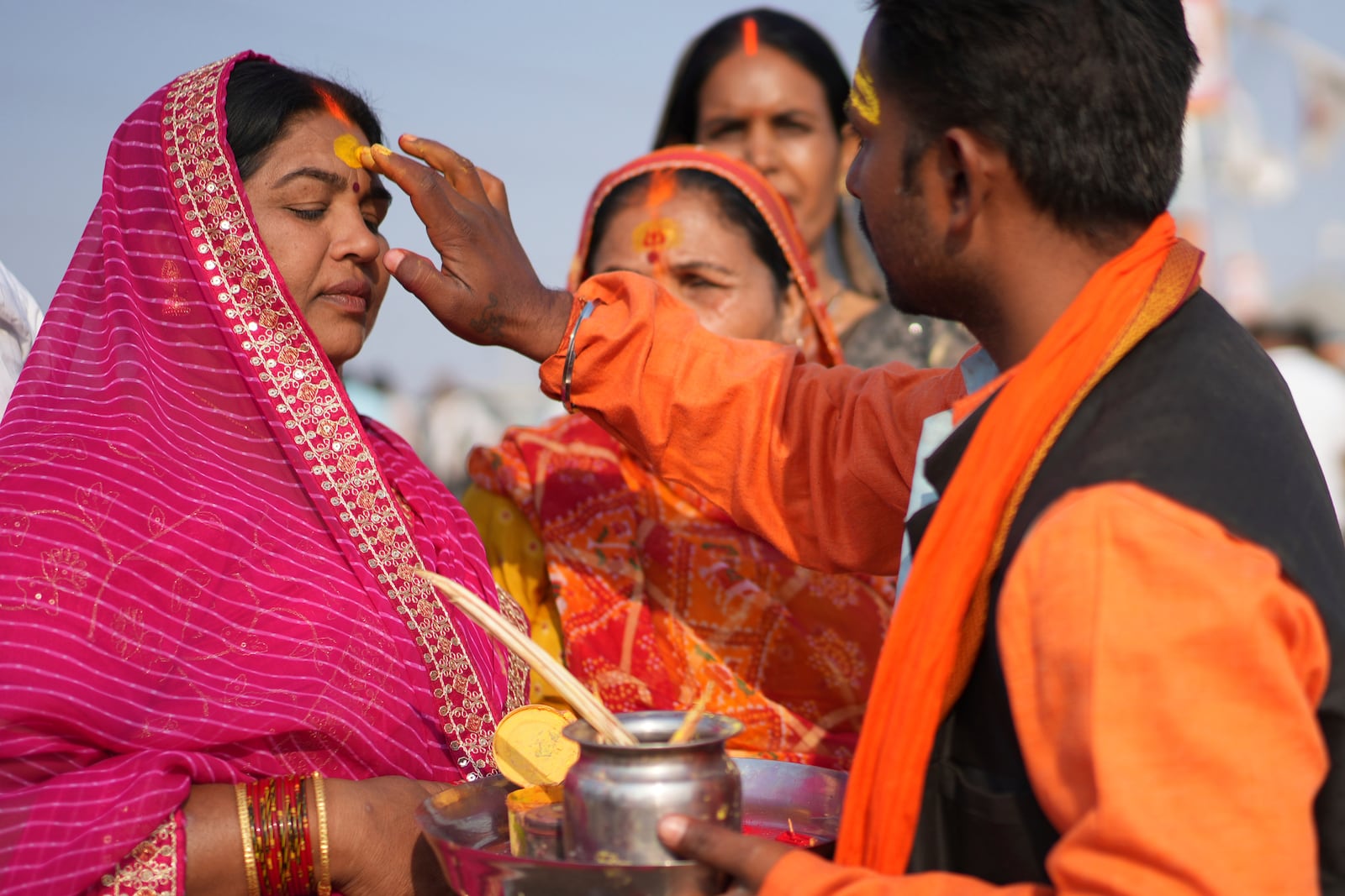 A Hindu priest puts a sacred mark on the forehead of a devotee at the confluence of the Ganges, the Yamuna, and the Saraswati rivers during the 45-day-long Maha Kumbh festival in Prayagraj, India, Tuesday, Jan. 28, 2025. (AP Photo/Deepak Sharma)