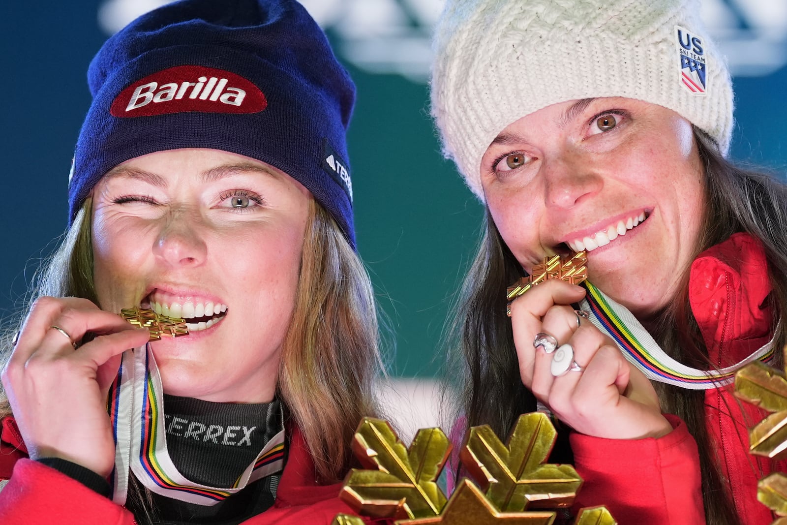 United States' Mikaela Shiffrin, left, and United States' Breezy Johnson bite their gold medals for a women's team combined event, at the Alpine Ski World Championships, in Saalbach-Hinterglemm, Austria, Tuesday, Feb. 11, 2025. (AP Photo/Giovanni Auletta)